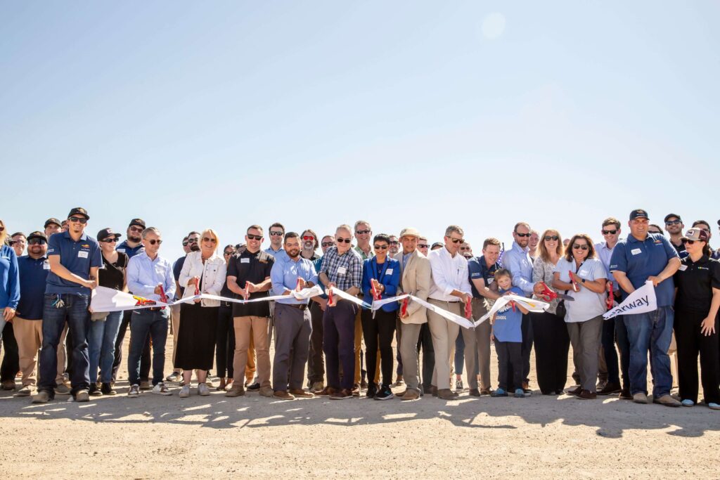 Group of Peninsula Clean Energy staff and partners participating in a ribbon-cutting ceremony at a renewable energy project site.