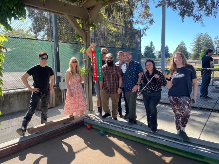 PCE staff members gather around a bocce ball court